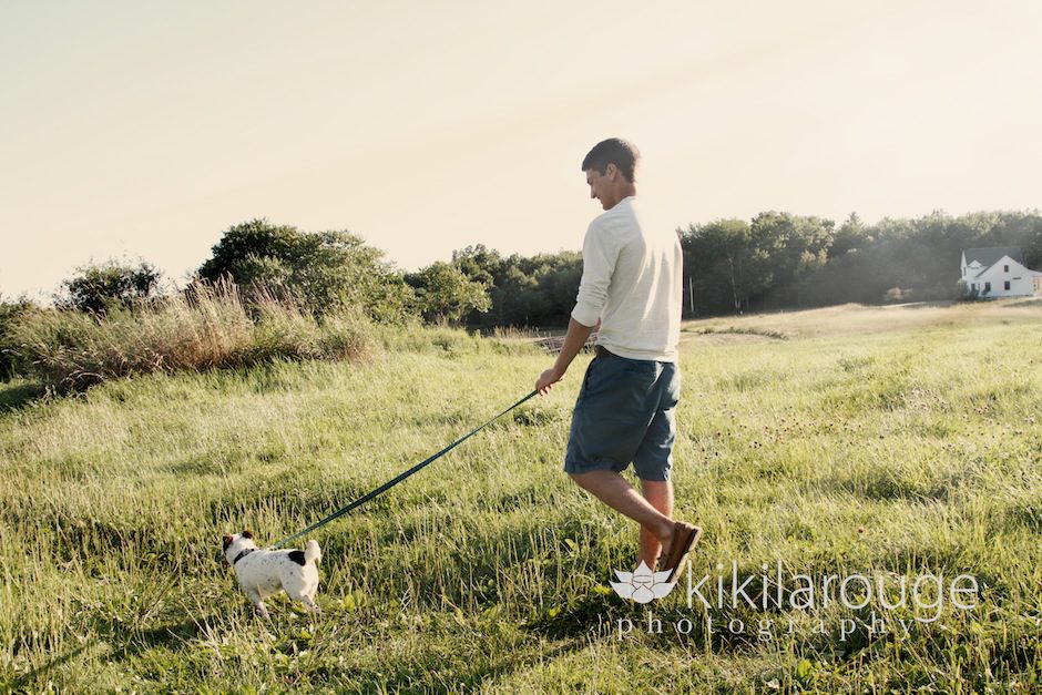 Boy walking with dog in field