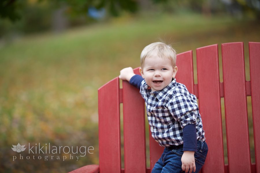 Laughing little boy on red chair