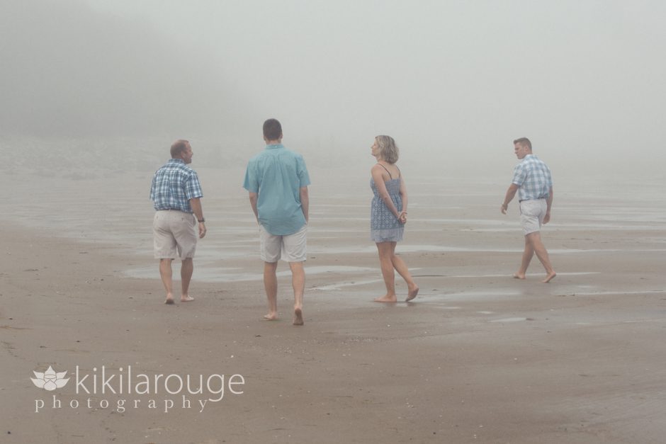 Family walking the beach in the fog