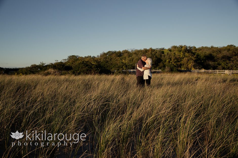 Couple kissing in grass at beach