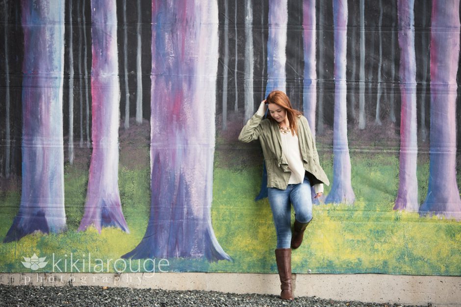 Redhead girl leaning on mural in city
