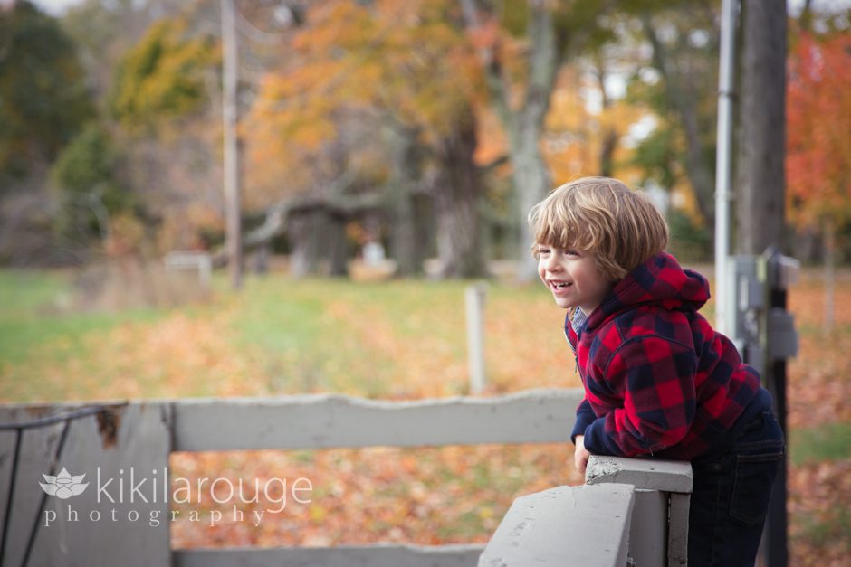 Little boy on farm fence laughing