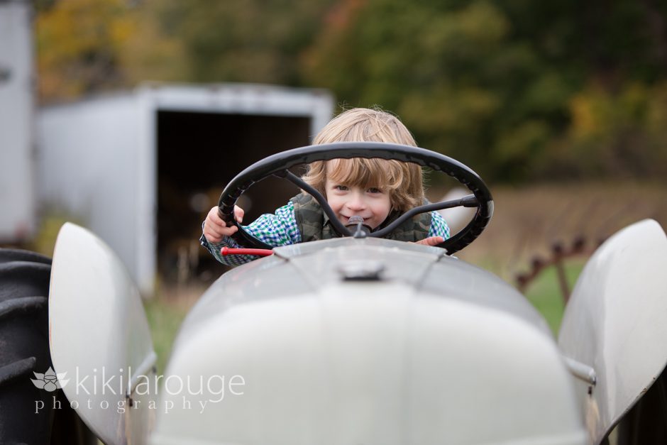 Boy looking through steering wheel on tractor