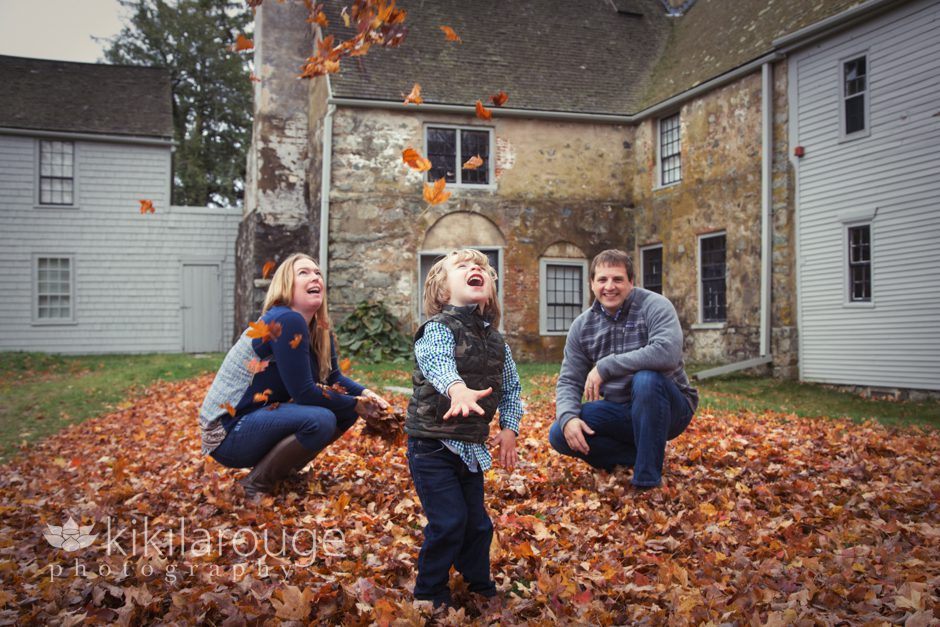 Family Playing in the Fall leaves at a farm