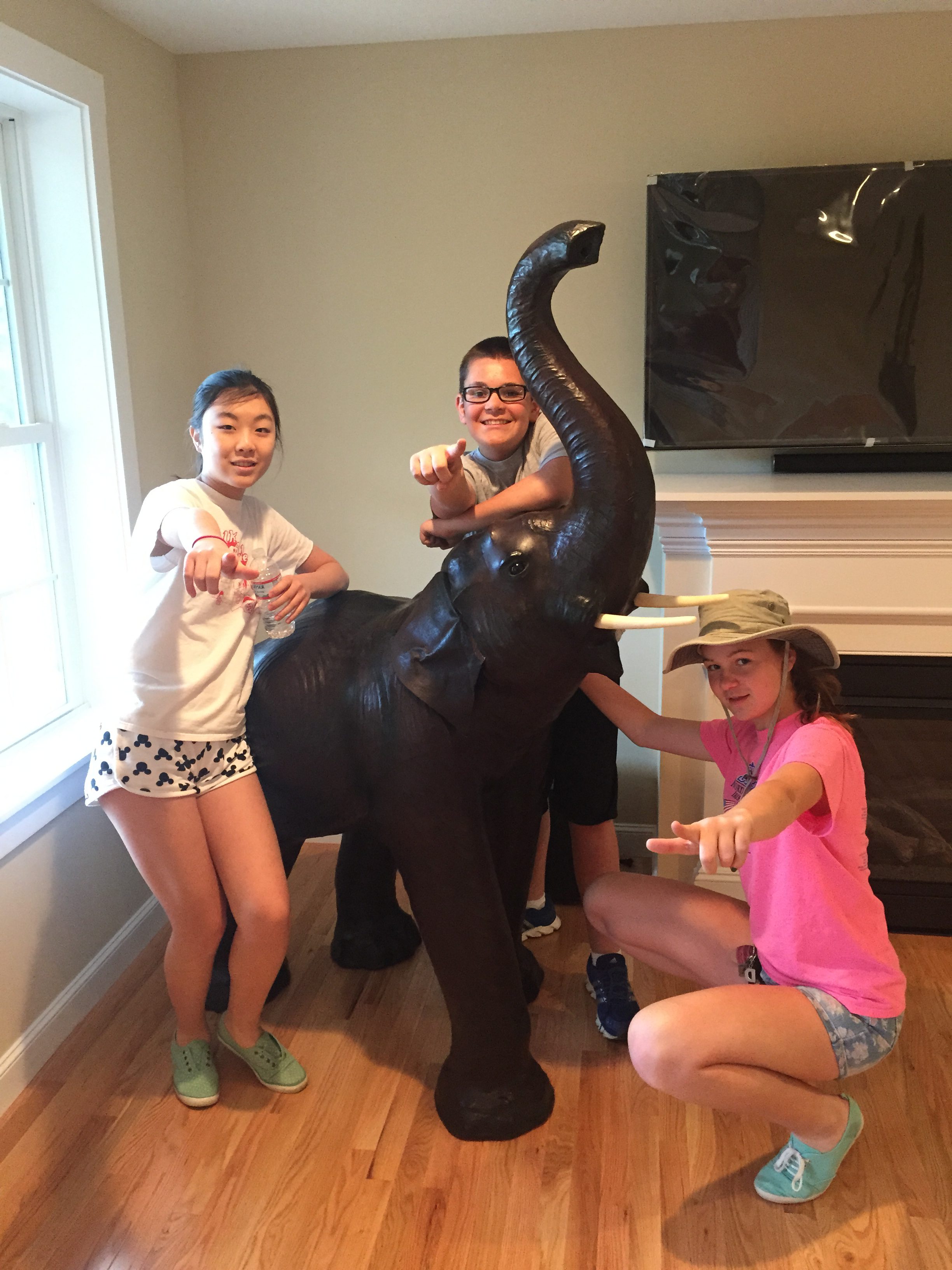 Three kids with fake elephant in a living room