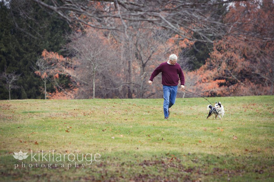 Man running in field with puppy