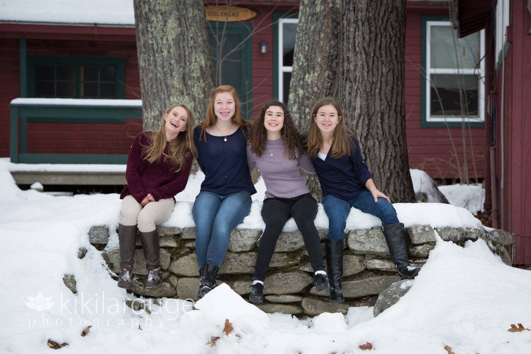 Four cousins sitting on snowy wall