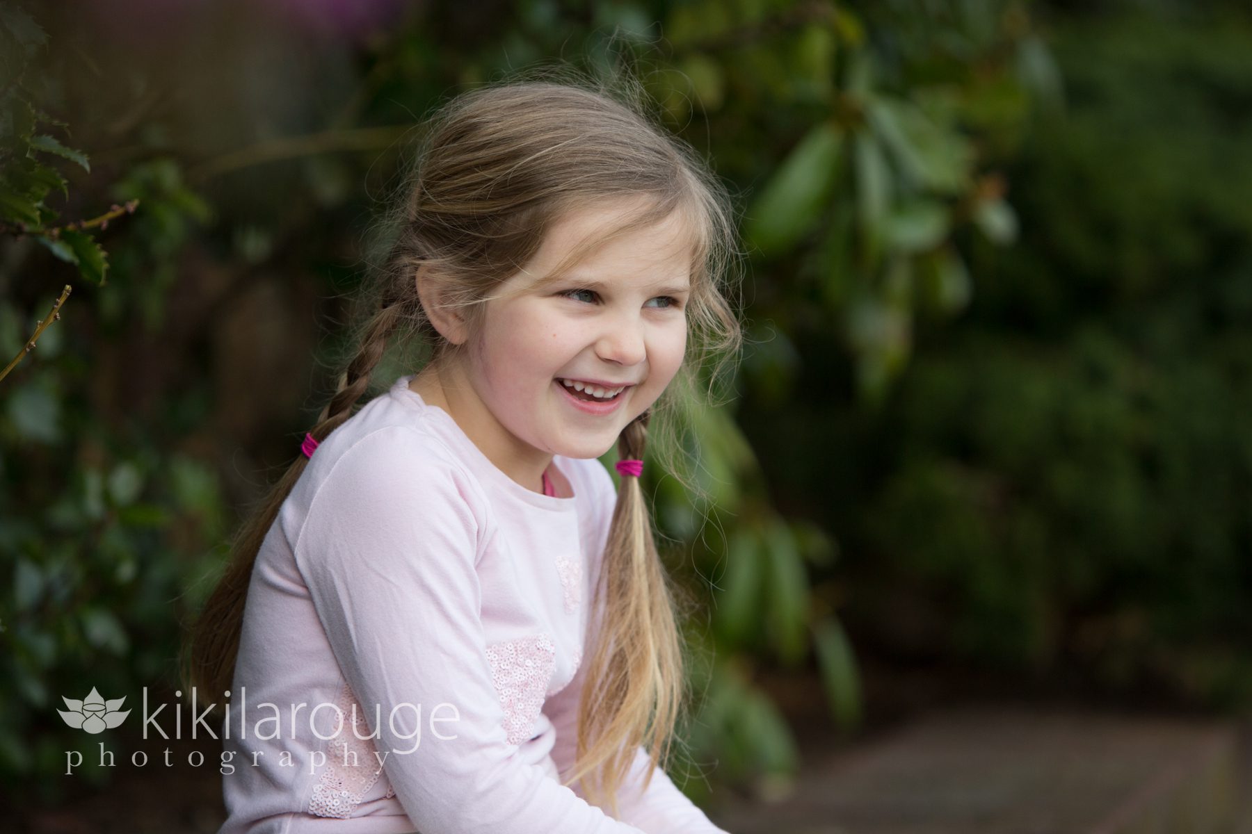 Little girl pigtails laughing in garden