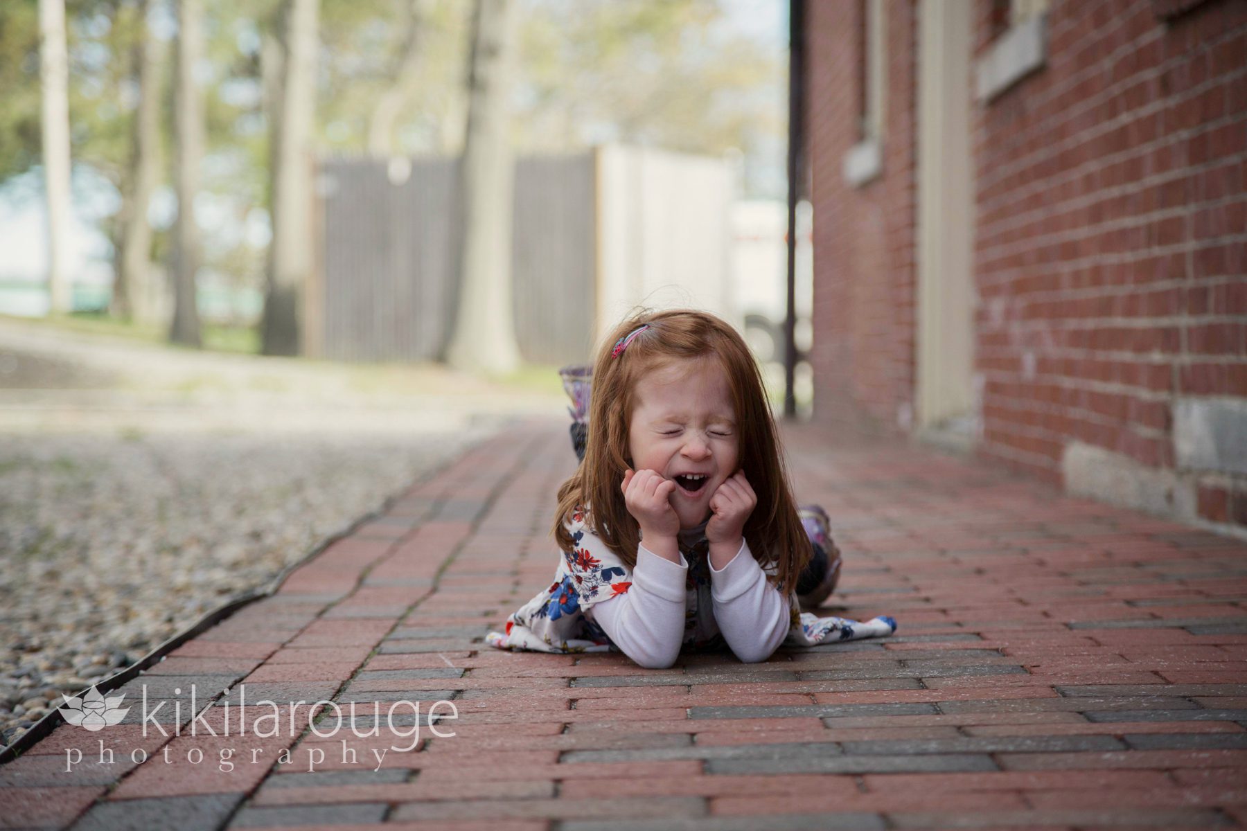 Redhead little girl laying on ground