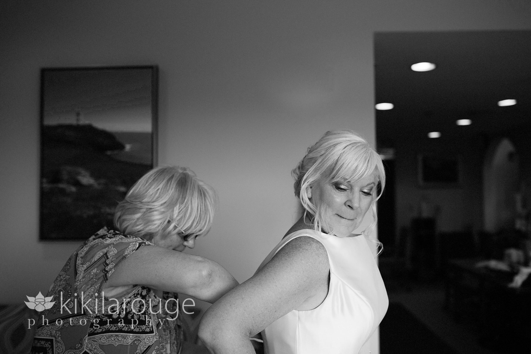 Bride getting dress on with sister