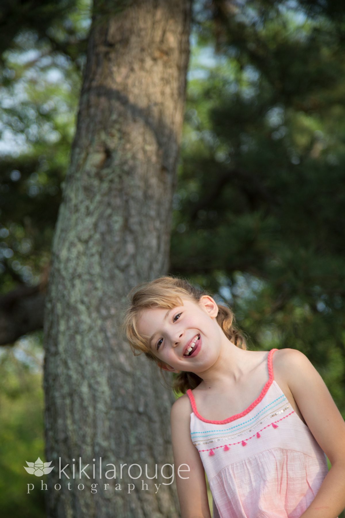 Little girl smiling by tree