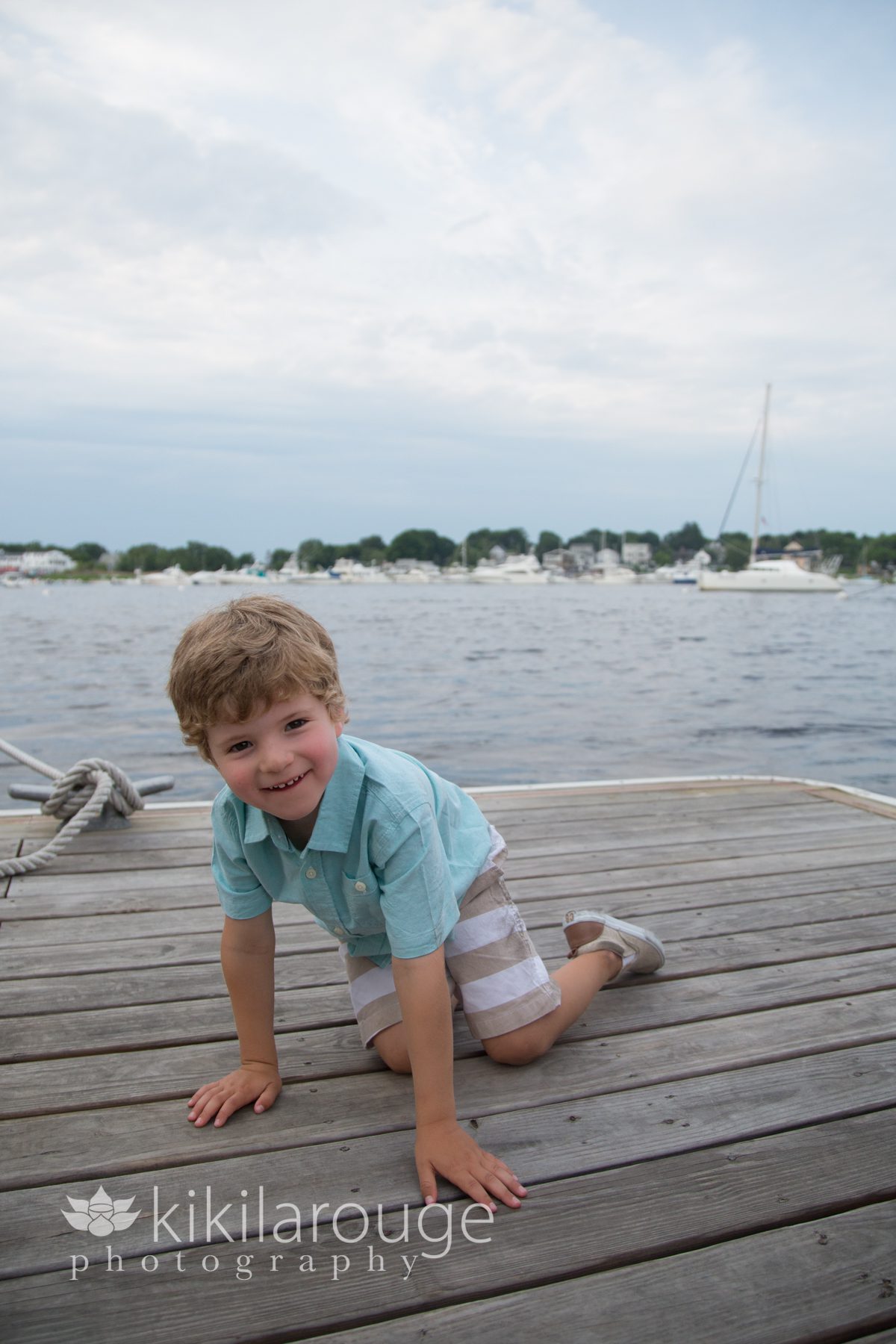 Little boy crawling and smiling on dock