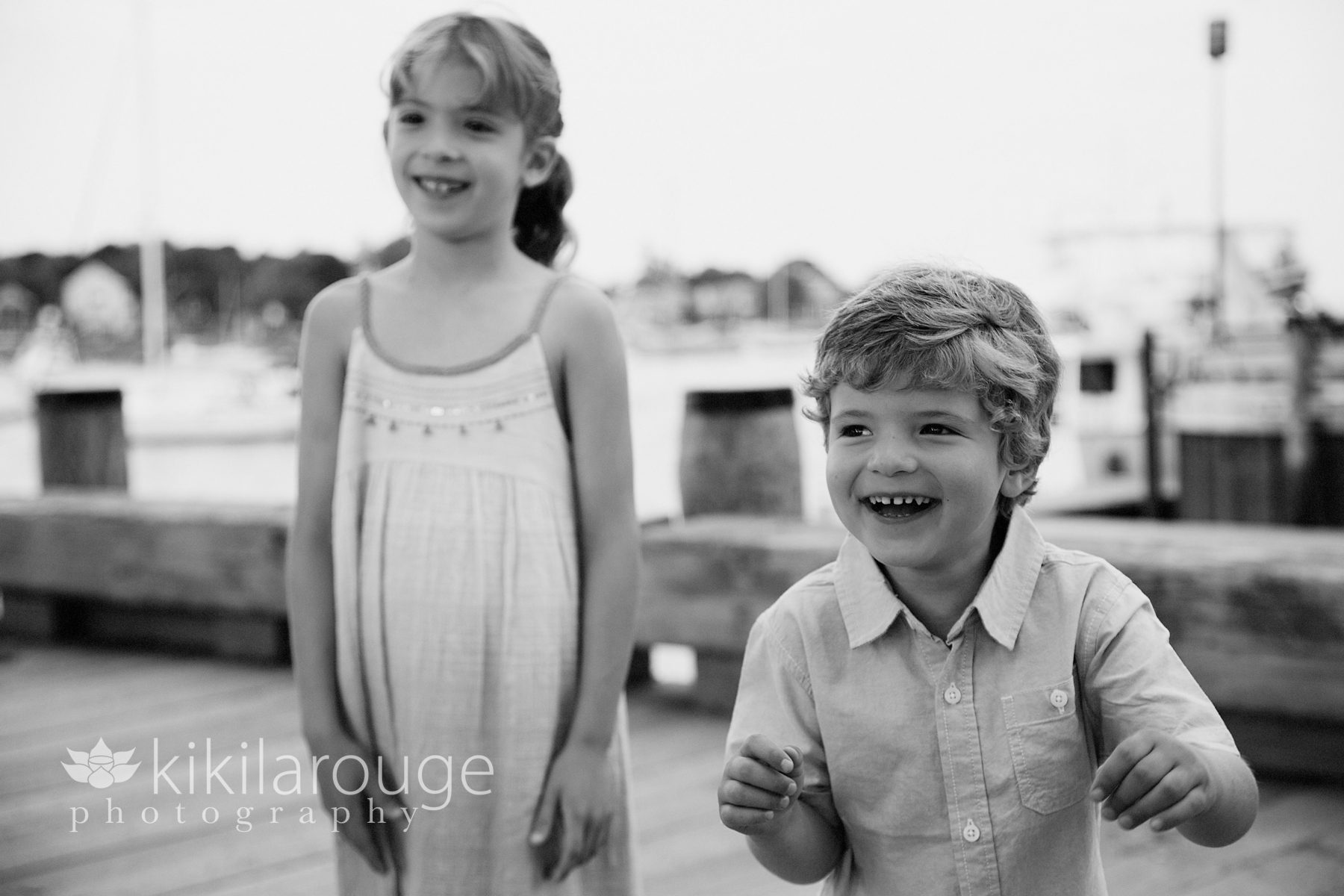 Brother and sister laughing on pier
