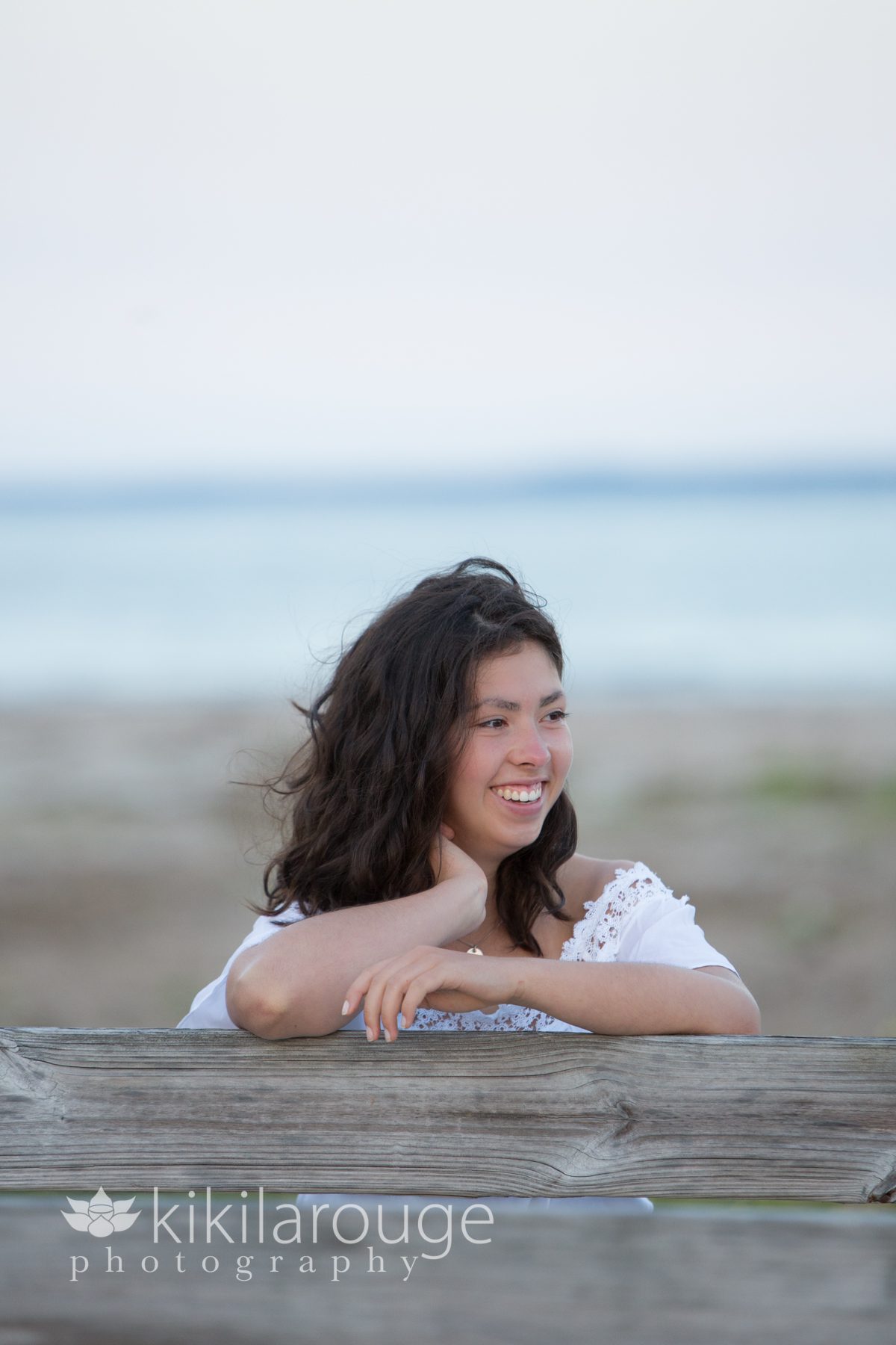 Senior girl leaning on boardwalk at beach