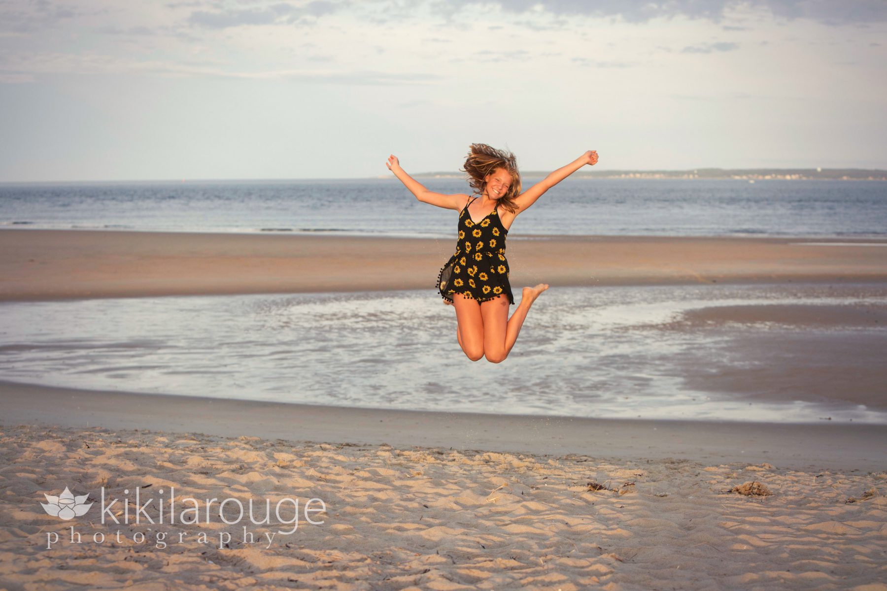 Young girl jumping at sunset at beach