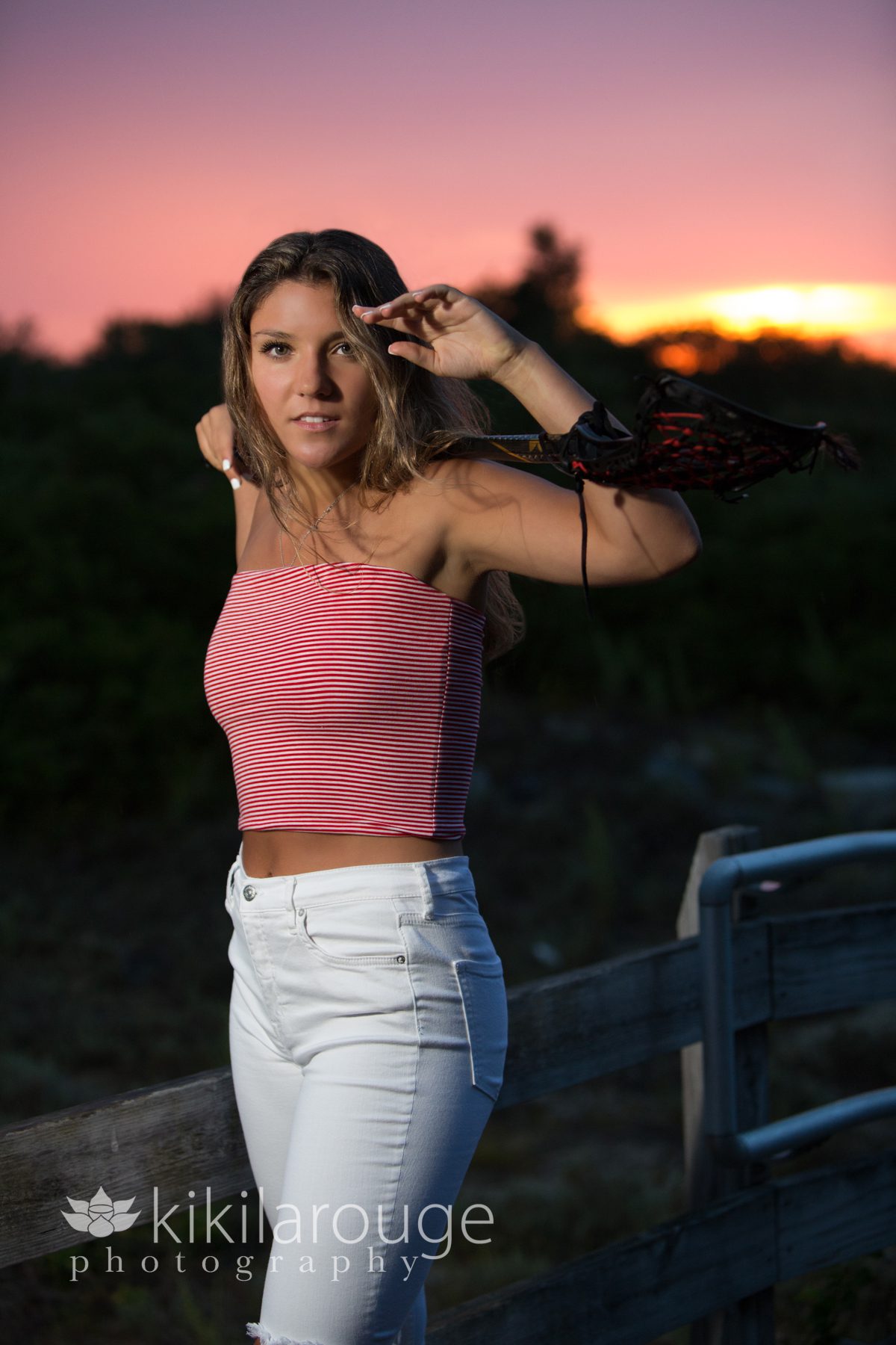 Senior Portrait Girl with lacrosse stick hot pink sunset