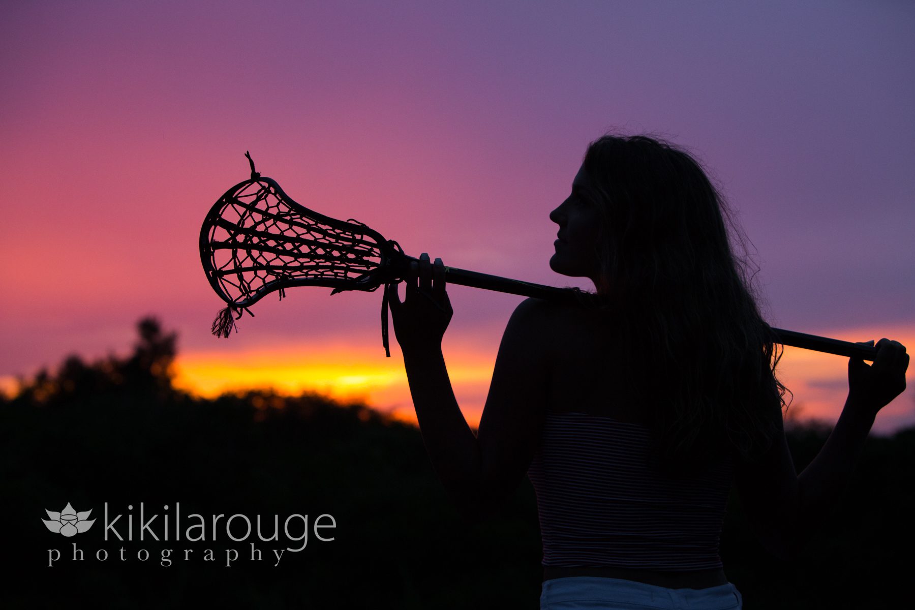 Pink sunset silhouette with lacrosse stick