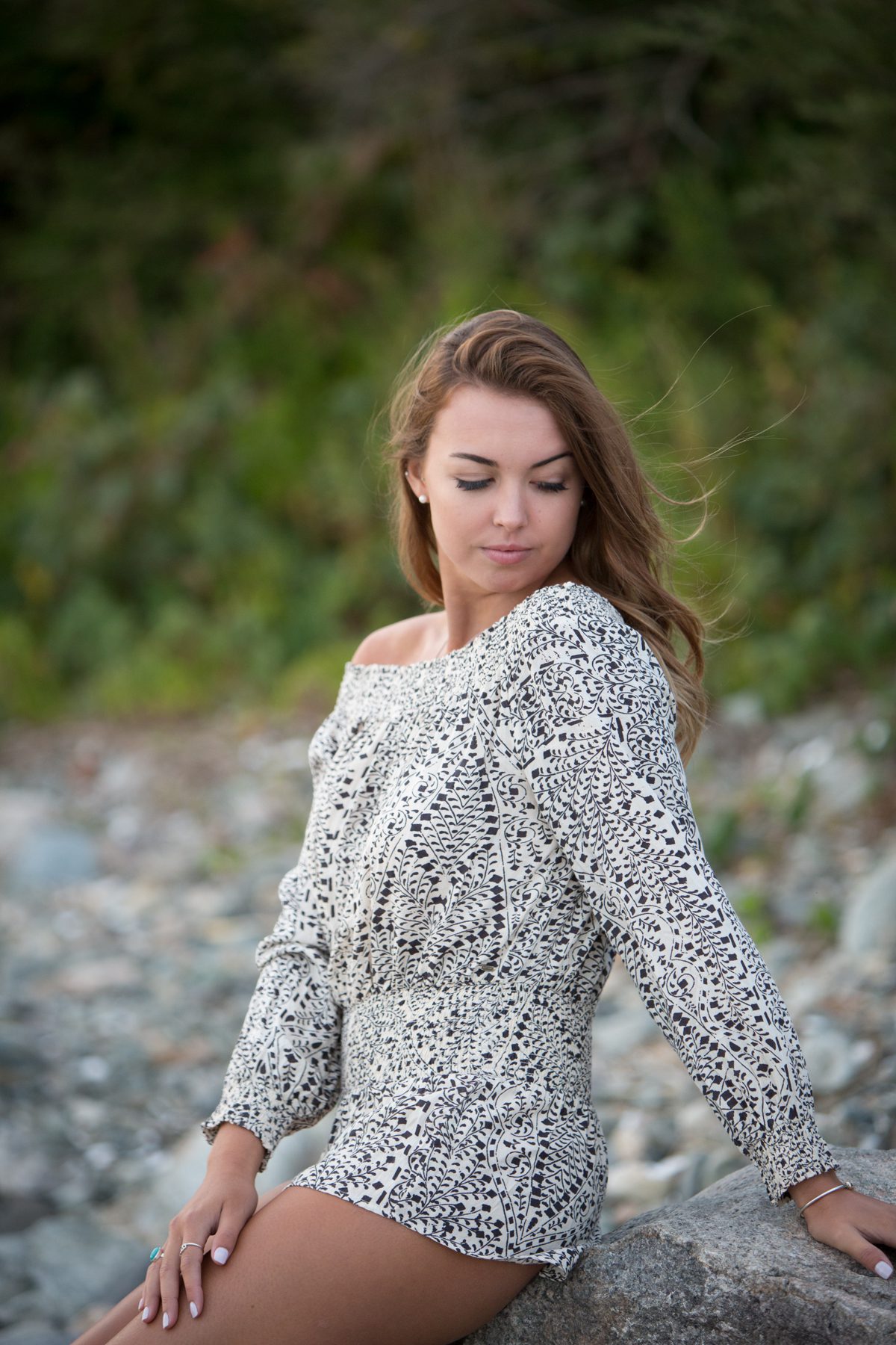 Girl in romper on rocks at beach