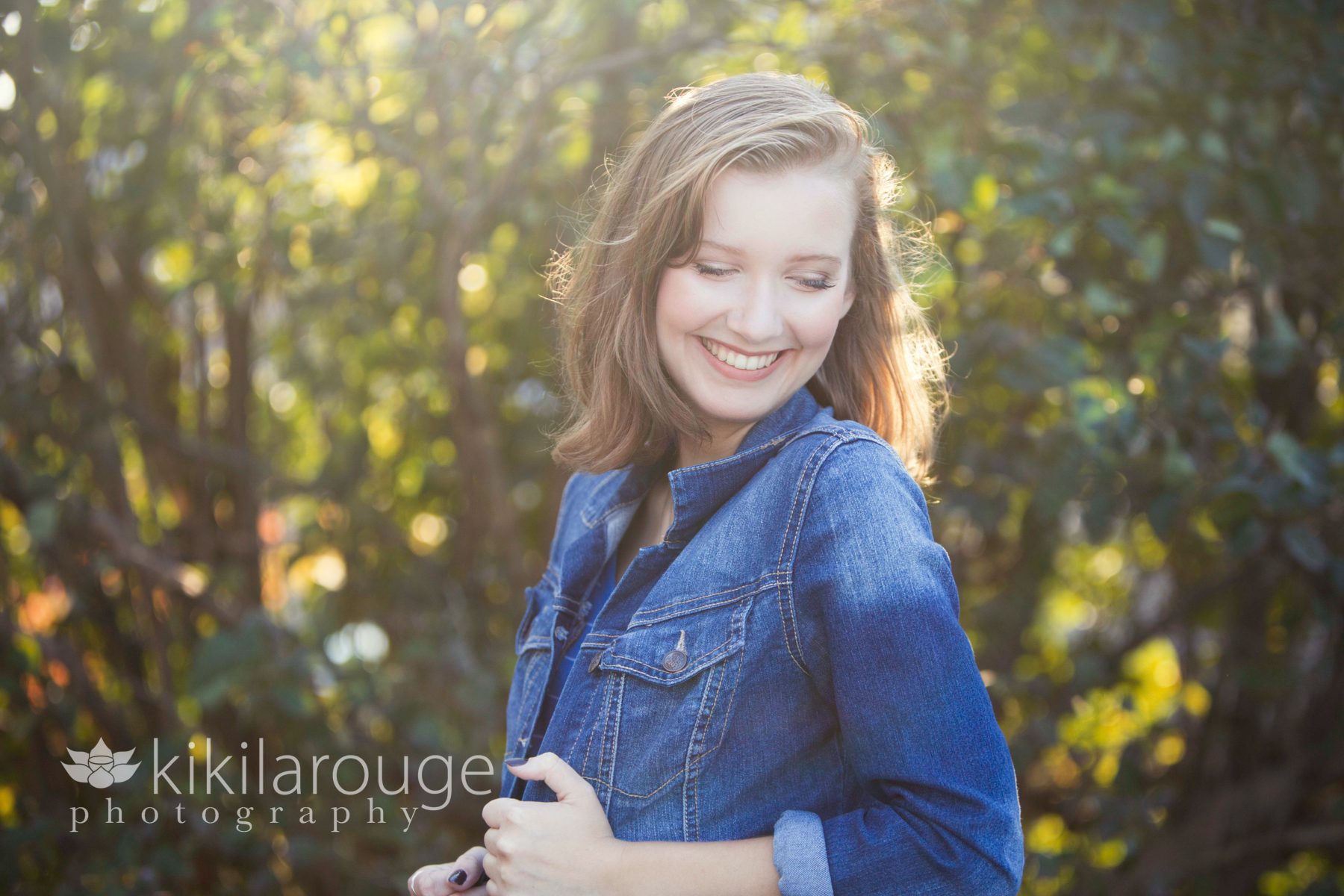 Senior Portrait in Dungaree jacket with sun flare