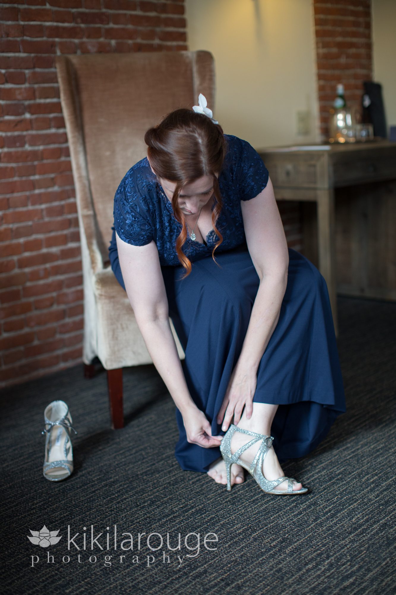 Bride in navy blue dress putting on shoes