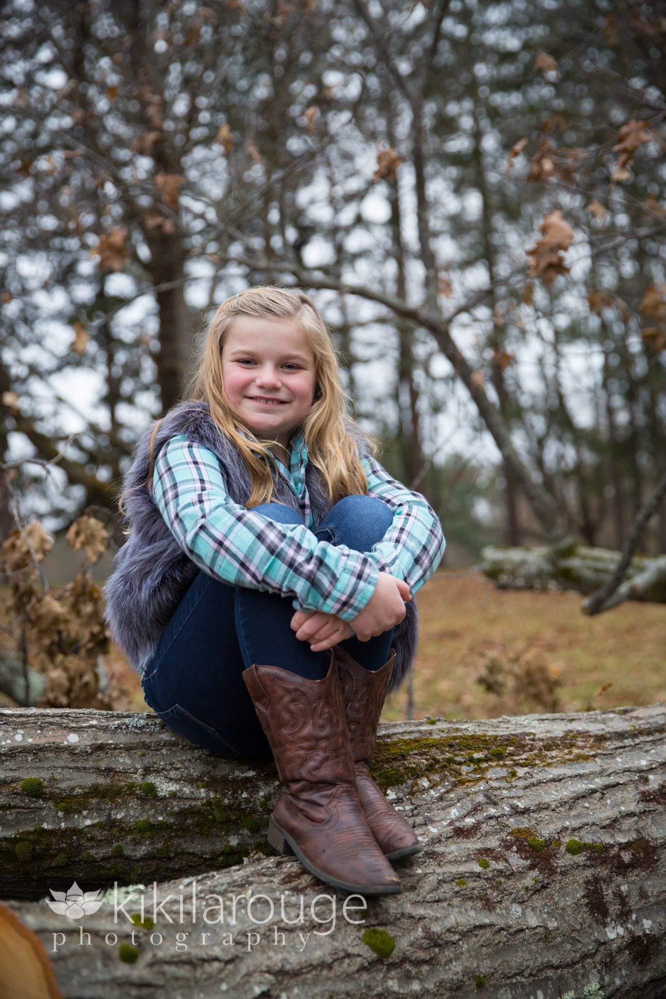 Girl in cowboy boots on log