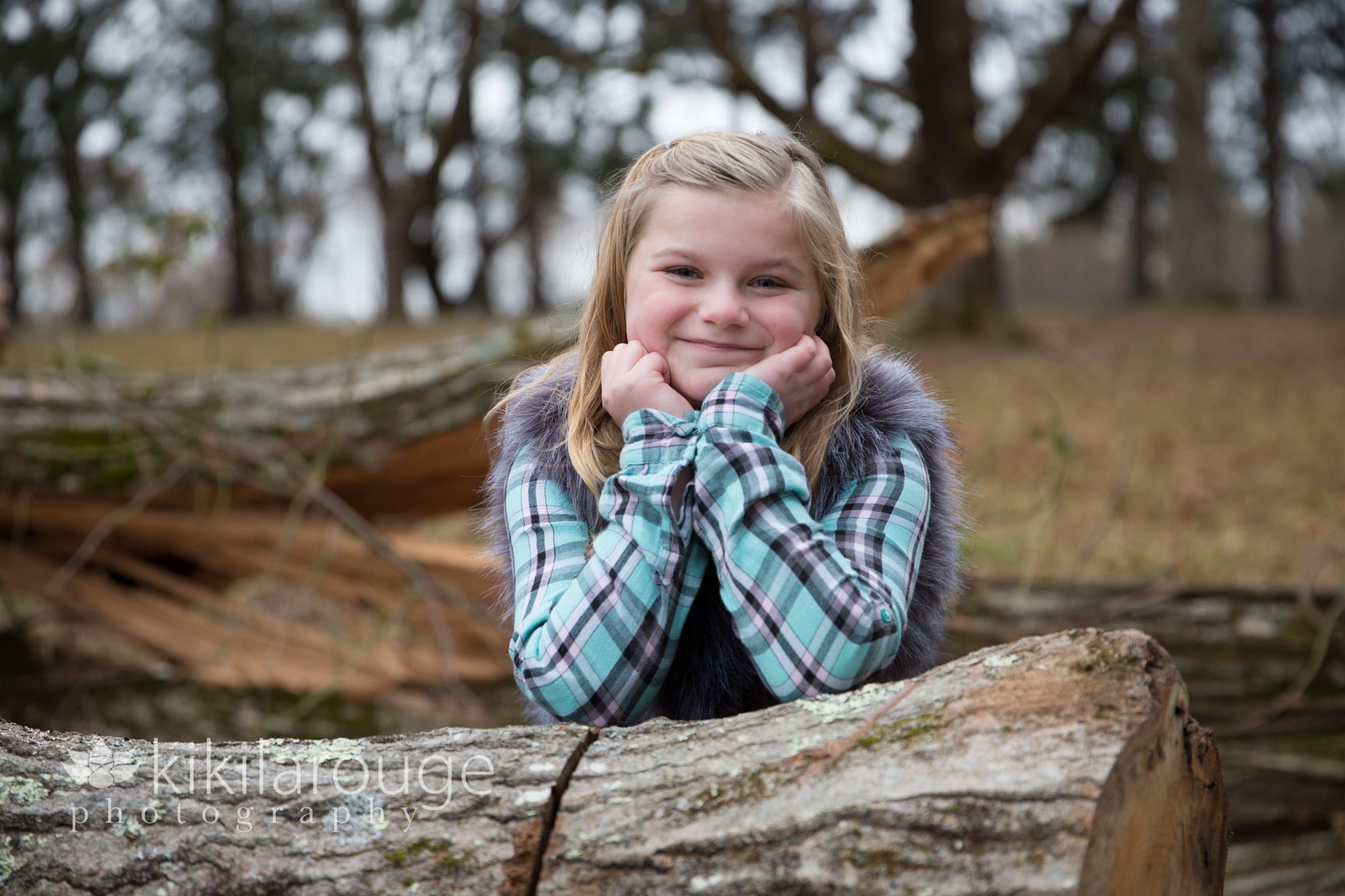 Young girl leaning on log