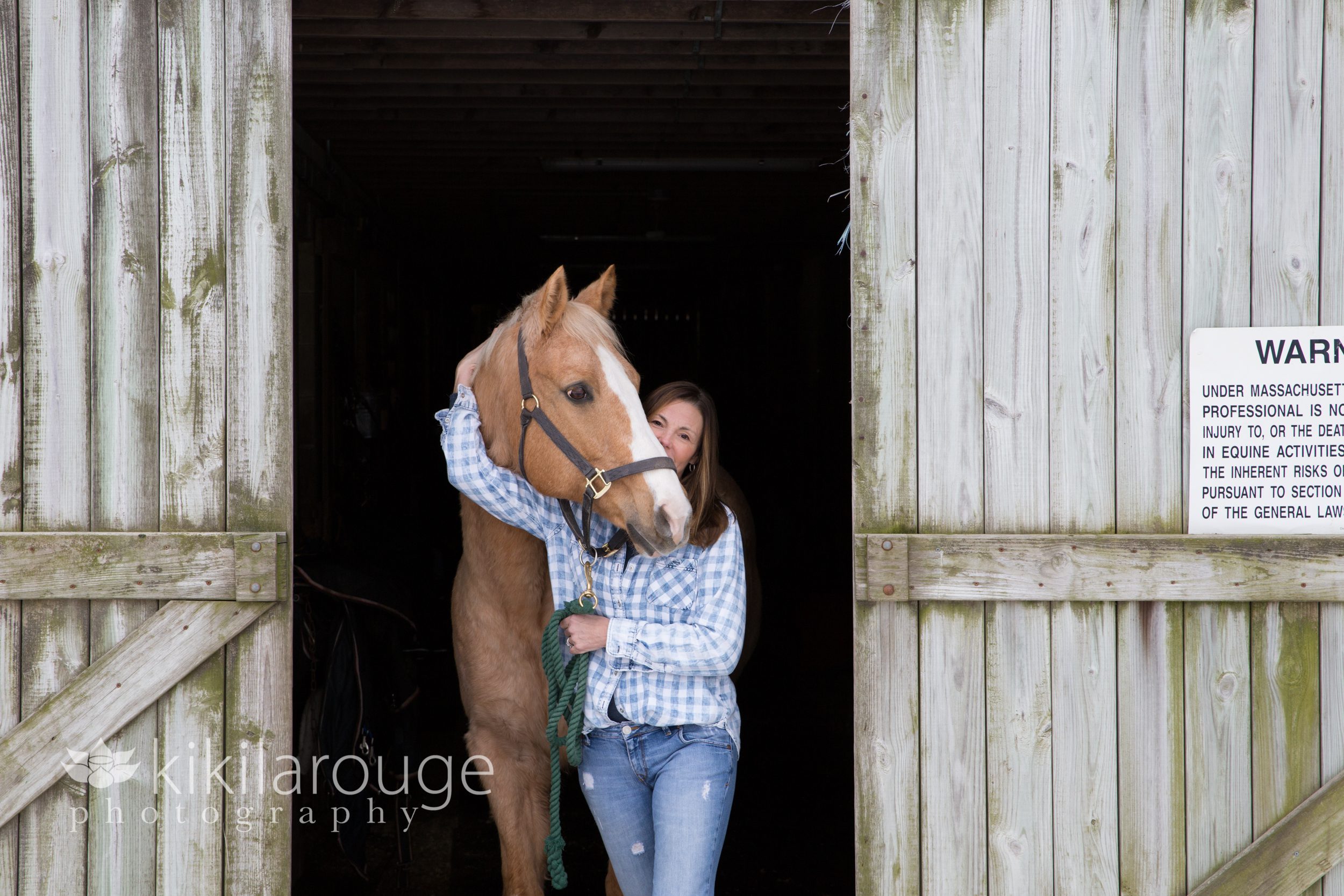 Woman with horse at barn doors