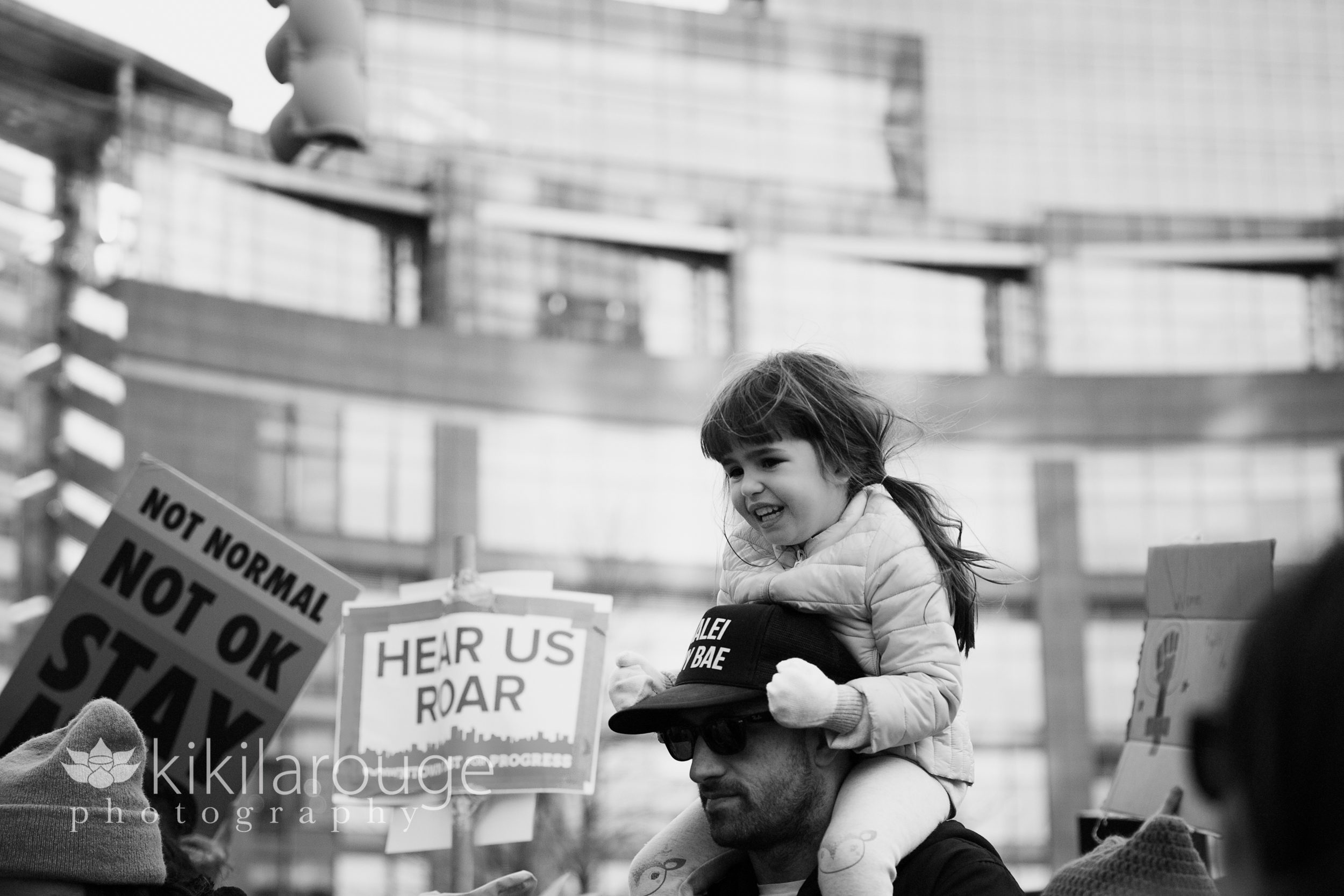 Young girl on Dad shoulders at protest