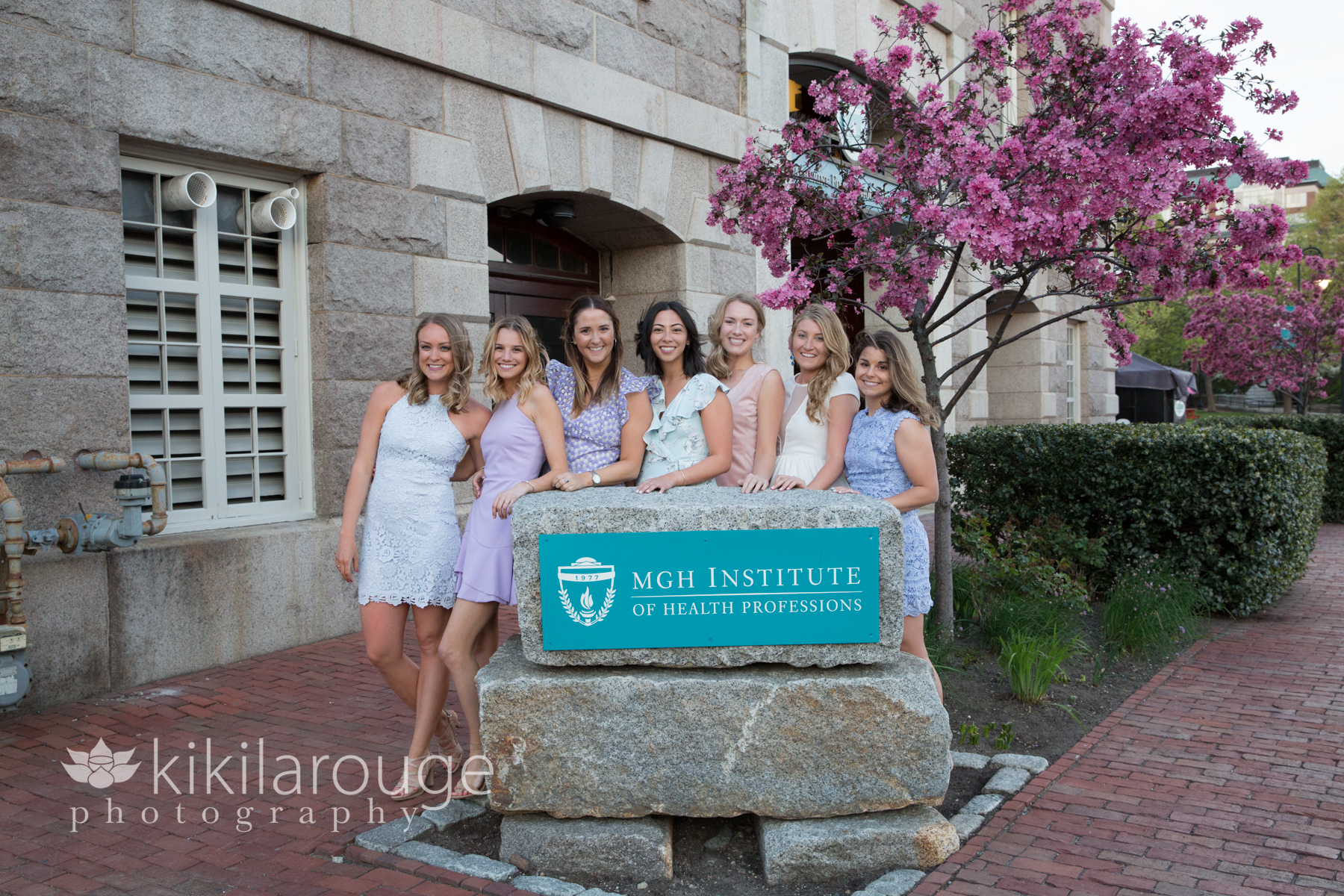 Graduates in front of MGH Institute Sign