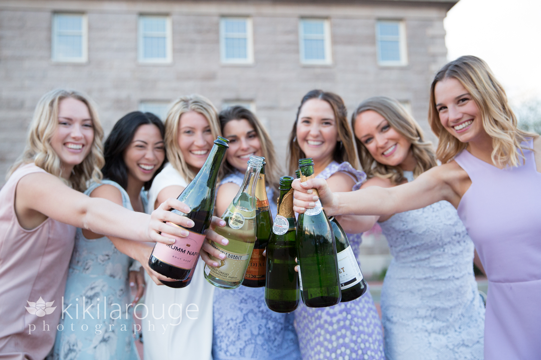 Girls all with champagne bottles toasting