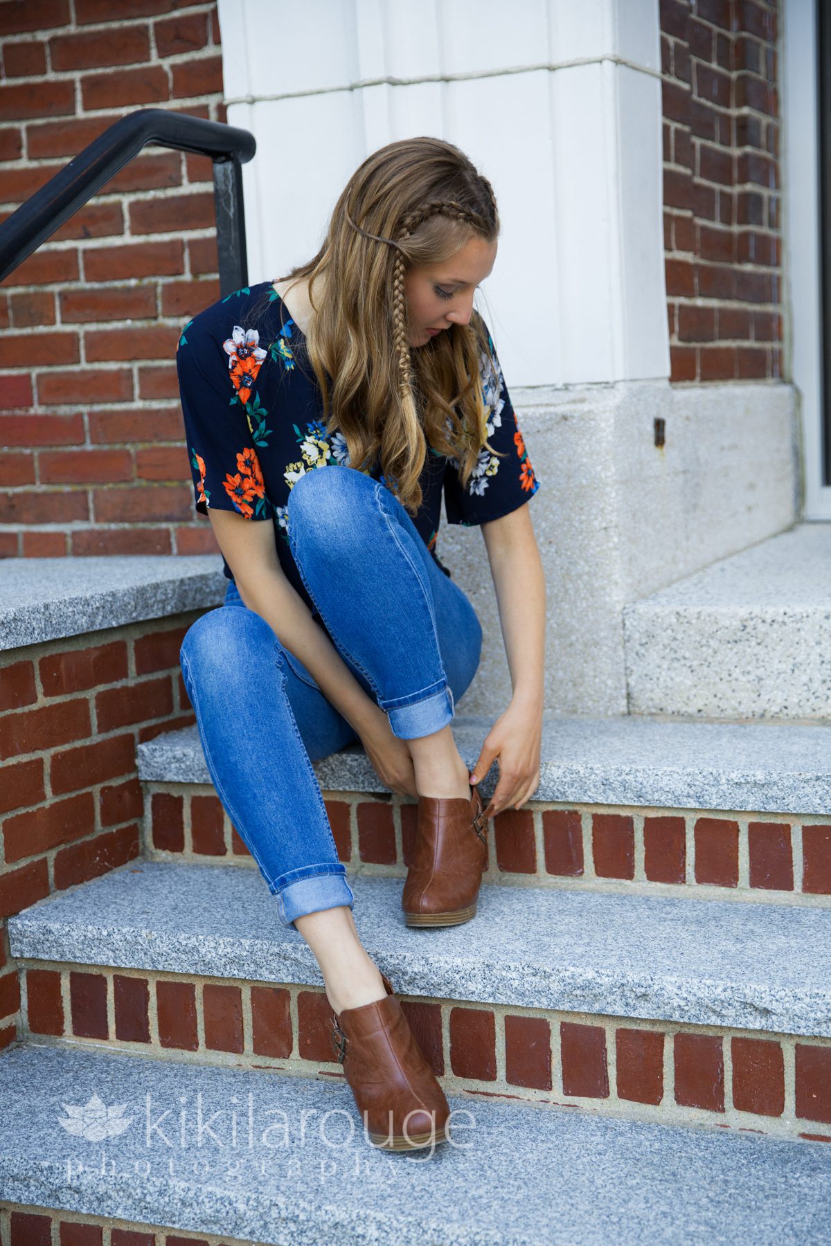 Girl sitting on brick steps adjusting shoes