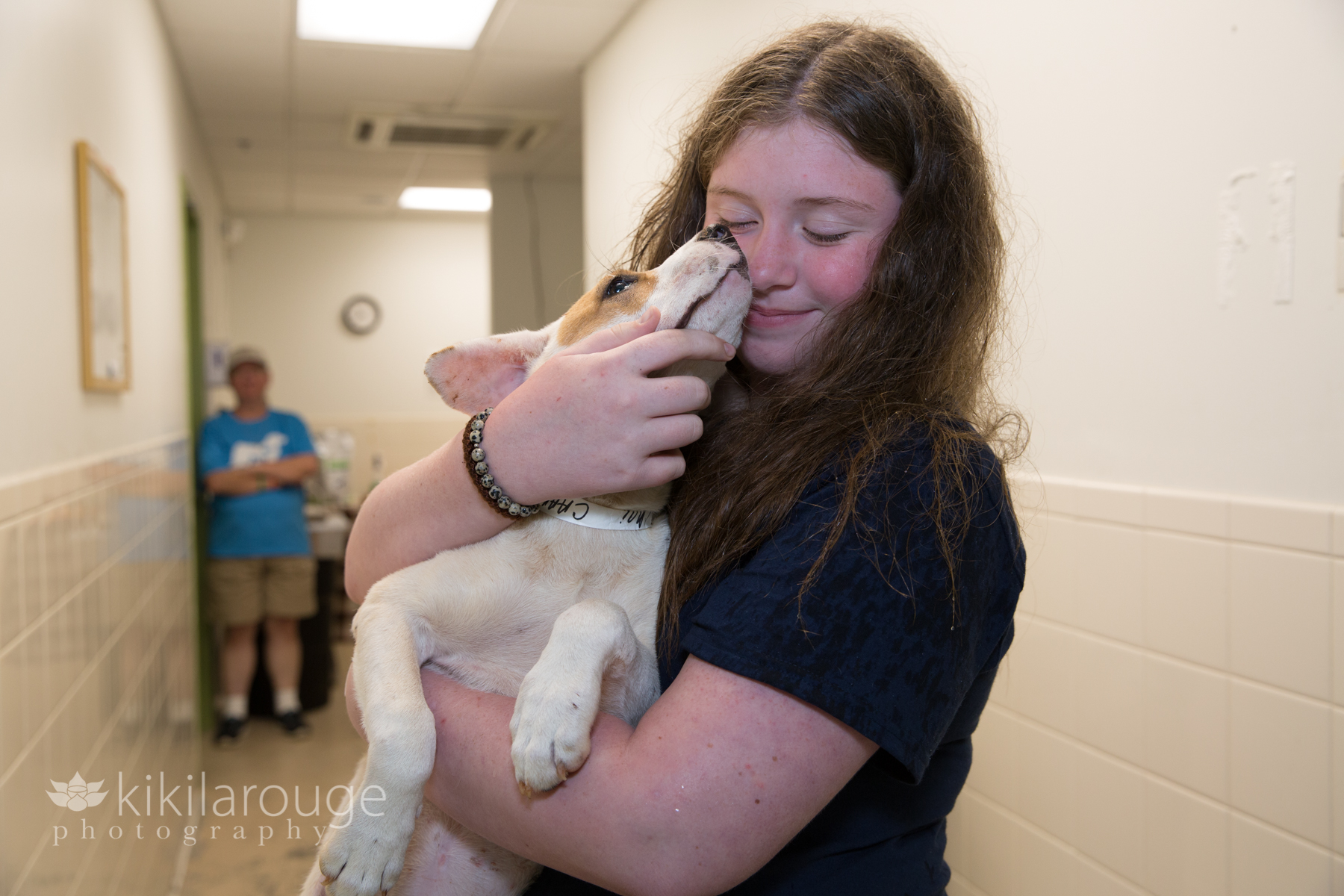 White rescue dog giving shelter worker a kiss