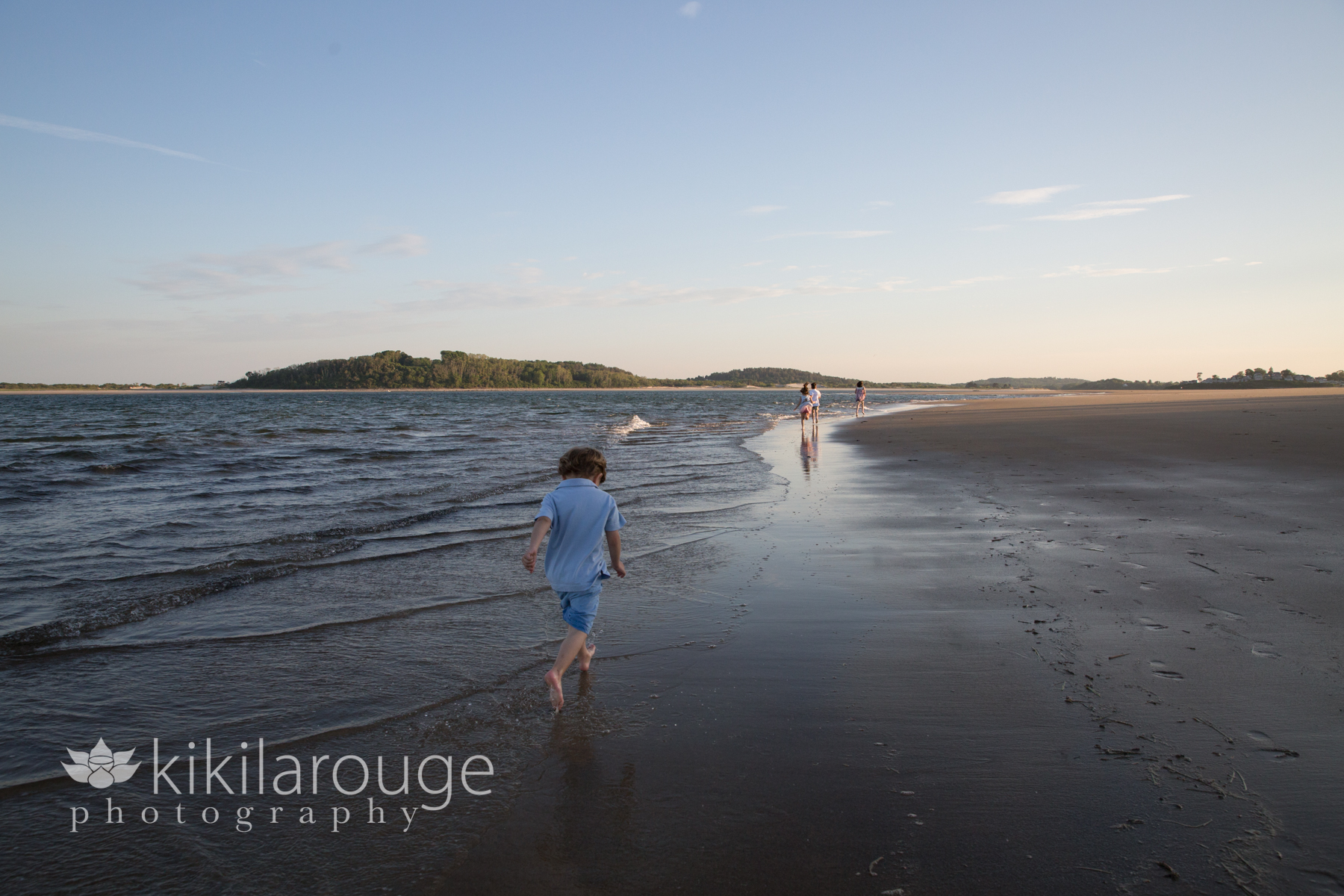 Little boy running after cousins on the beach sunset