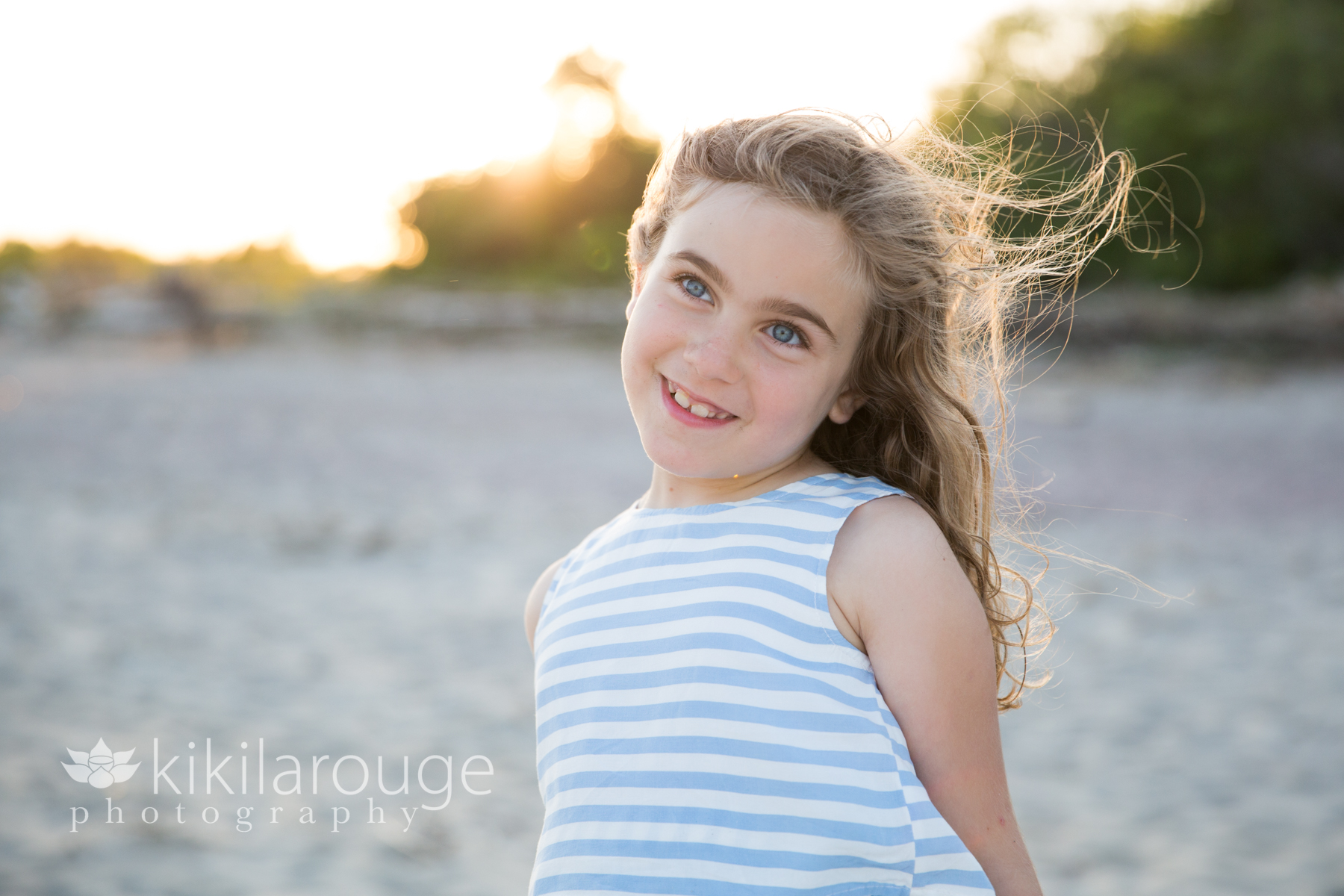 Girl smiling in dress at beach sunset