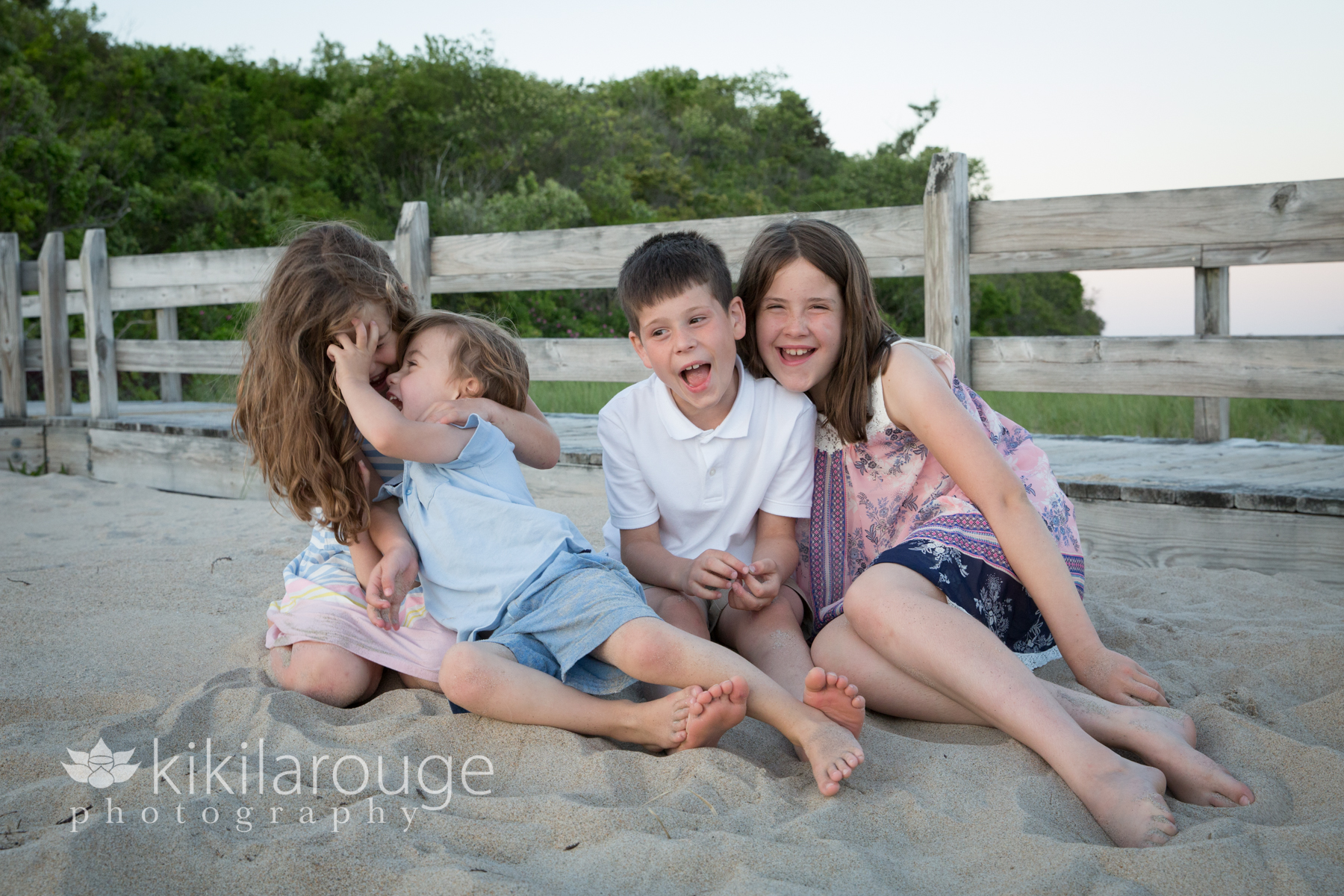 Four cousins at sunset beach laughing