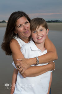 Mom hugging young son in white tops at beach