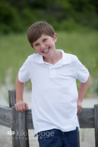 Young boy white shirt smiling on Sandy Point boardwalk