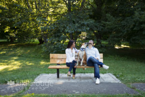 Couple sitting with tan and white dog on JP arboretum bench