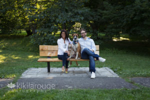 Couple sitting with tan and white dog on JP arboretum bench