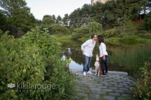 Couple kissing at JP pond and dog looking up