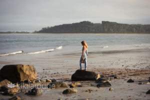 teenage girl in denim and checked blue halter top at beach