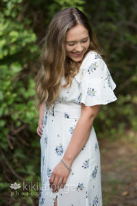 Girl in forest with long white floral dress