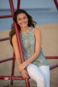 Girl in green top leaning on a red lifeguard stand