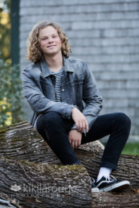 Senior Portrait boy denim jacket on logs