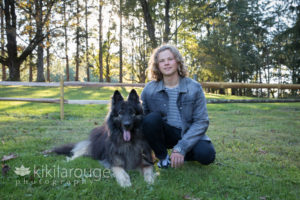 Teen boy portrait with dog in field