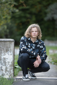Boy in floral dress shirt in state park senior portrait