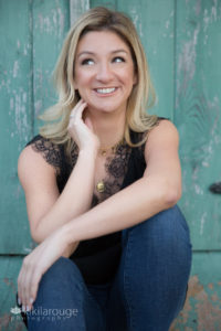 Woman smiling looking up with black top and jeans