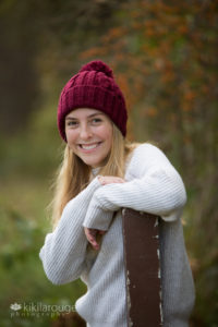 Senior portrait girl in maroon hat with pom pom