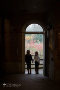 Two girls a barn door silhouetted