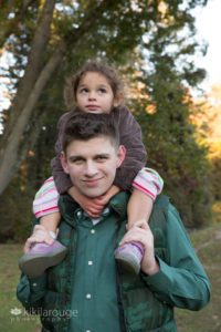 Teen boy with his three year old sister on his shoulders at park